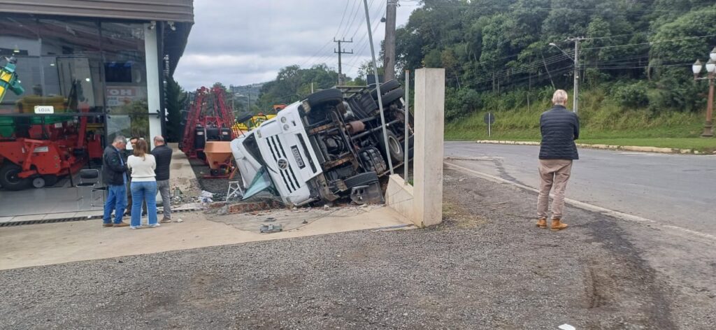 Caminhão baú tombou próximo à rotatória de acesso a Irati, na BR-153. Veículo carregava bebidas e atingiu a cerca de uma loja de máquinas agrícolas